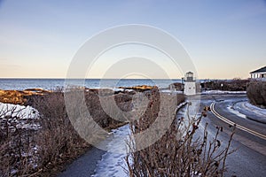 Ice on Marginal way in Ogunquit by the lobster point lighthouse in Maine in winter