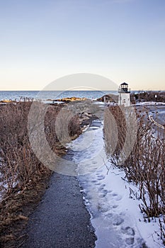 Ice on Marginal way in Ogunquit by the lobster point lighthouse in Maine in winter