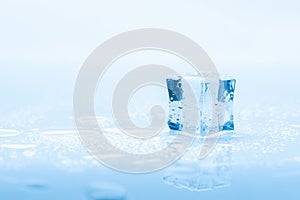 Ice one cube square with drops water clean on blue background