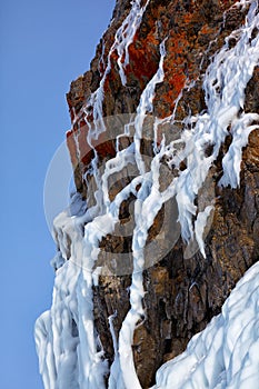 Ice over rocks wall on Baikal lake at winter