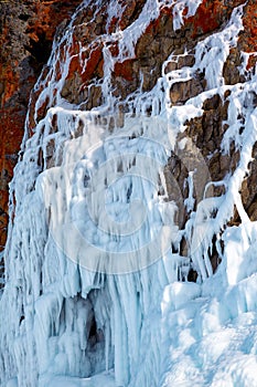 Ice over rocks wall on Baikal lake at winter