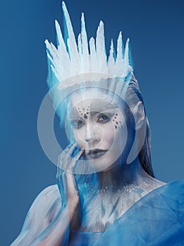 Ice queen with crystal crown against blue background