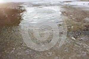 Ice on the road close up. Slippery ice-crusted ground surface