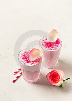 Ice rose latte in glass with pink flowers and petal on white or grey background