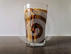 Ice shaked coffee with chocolate souce on glass