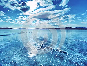 Ice shards on a frozen lake. The rays of the sun creat rainbow shadows