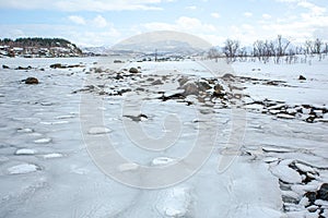 Ice Sheet Cracks Over Black Rocks