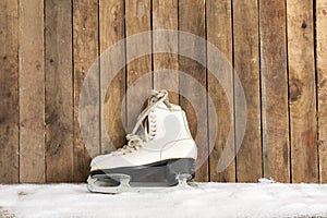 Ice skates against an weathered wooden wall