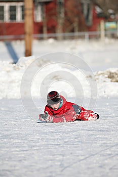 Ice skating boy fell down on the rink