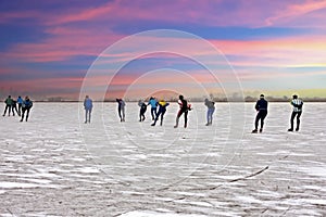 Ice skating on a cold snowy winterday in the countryside from the Netherlands at sunset