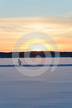 Ice skating in skandinavien winter sunset on frozen lake photo