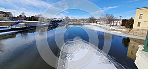 Ice and snow accumulate downstream of a highway bridge over the rock river in downtown fort atkinson wisconsin blue winter day