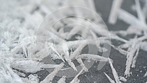 Ice and snow crystals forming spike shapes on frozen river, closeup macro detail, abstract winter background