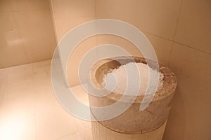 Ice tank in the luxurious hall of the bath and sauna with beige marble walls. Close-up