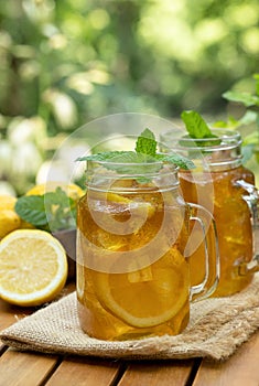 Ice tea in glass jars with lemon and mint