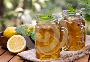 Ice tea in glass jars with lemon and mint