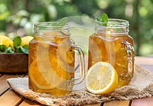 Ice tea in glass jars with lemon and mint