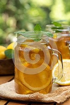 Ice tea in glass jars with lemon and mint