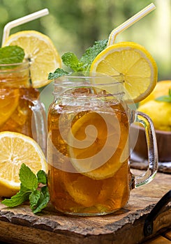 Ice tea in two glass jars with lemon and mint