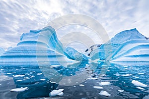 Iceberg in Antarctica floating in the sea, frozen landscape with massive pieces of ice reflecting on water surface, Antarctic photo