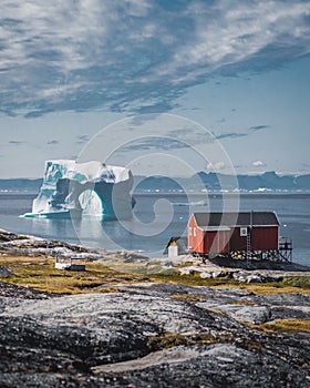 Iceberg with an arch in Antarctic Greenland waters against the backdrop of the mountains of the Arctic Peninsula. Small