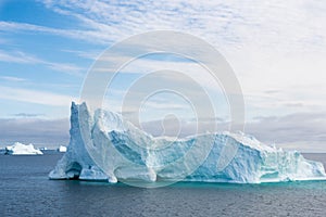 Iceberg with gate, beautiful shaped iceberg, surrounded by turquoise shiny water, Greenland