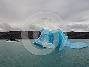 Iceberg and boat comparation in Lake Argentina in front of tha U photo
