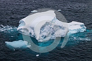 Iceberg in calm sea. Blue Ice.