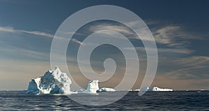 Iceberg in Disko Bay. Western Greenland. Sunset sky background.