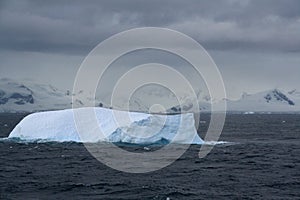 Iceberg glowing in an overcast dawn