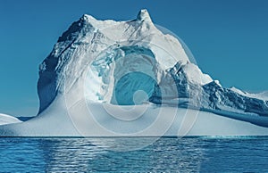 Iceberg with a huge cave at the mouth of the Icefjord in Ilulissat, Greenland