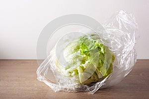 Iceberg lettuce salad vegetable in plastic bag. single use plastic packaging issue