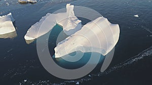 Iceberg melt in clear ocean drone top down view