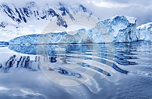 Iceberg Reflection Snow Mountains Blue Glaciers Dorian Bay Antarctica photo