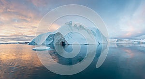 Iceberg at sunset. Nature and landscapes of Greenland. Disko bay. West Greenland. Summer Midnight Sun and icebergs.