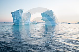 Iceberg at sunset. Nature and landscapes of Greenland. Disko bay. West Greenland. Summer Midnight Sun and icebergs.