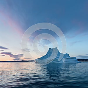 Iceberg at sunset. Nature and landscapes of Greenland. Disko bay. West Greenland. Summer Midnight Sun and icebergs. Big blue ice