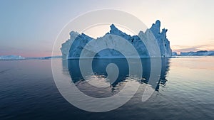 Iceberg at sunset. Nature and landscapes of Greenland. Disko bay. West Greenland. Summer Midnight Sun and icebergs. Big blue ice