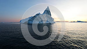 Iceberg at sunset. Nature and landscapes of Greenland. Disko bay. West Greenland. Summer Midnight Sun and icebergs. Big blue ice