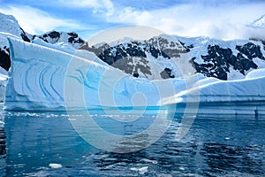 Iceberg with turquoise and blue shiny colors and texture in water of  Southern Ocean, Pradise Bay, Antarctica