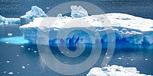 Iceberg with turquoise and blue shiny colors and texture in water of  Southern Ocean, Pradise Bay, Antarctica