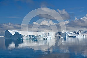 Icebergs in Antarctica, huge table iceberg, tabular iceberg with gate and reflections