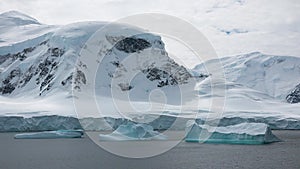 Icebergs and glaciers in Antarctica. Landscape of snowy mountains and icy shores in Antarctica. Beautiful blue iceberg