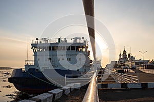 Icebreakers on the background of the sunset. Ice-drift on the Northern Dvina. Mikhailo-Archangel Cathedral photo