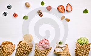 Icecreams with fruit and nut ingredients - colorful ice cream with cones on a white background