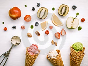 Icecreams with fruit and nut ingredients - colorful ice cream with cones on a white background