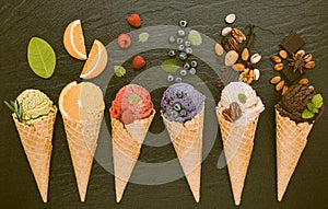 Icecreams with fruit and nut ingredients - ice cream cones on a black background