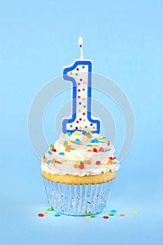 Iced birthday cupcake with with lit number 1 candle