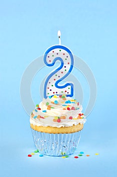 Iced birthday cupcake with with lit number 2 candle