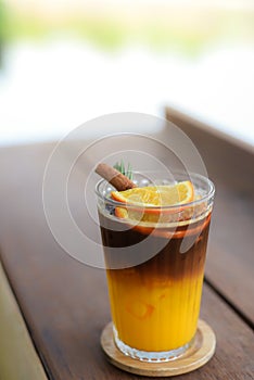 Iced Black coffee mixed with orange juice in glass topping with sliced orange